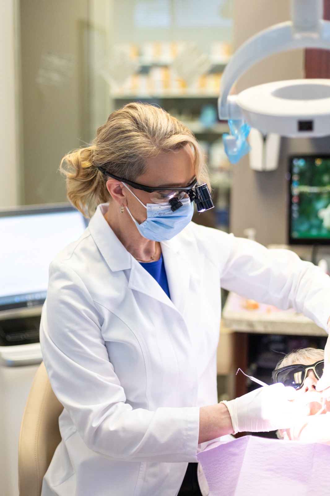 Dr. House examining a patient's restored tooth at the chair