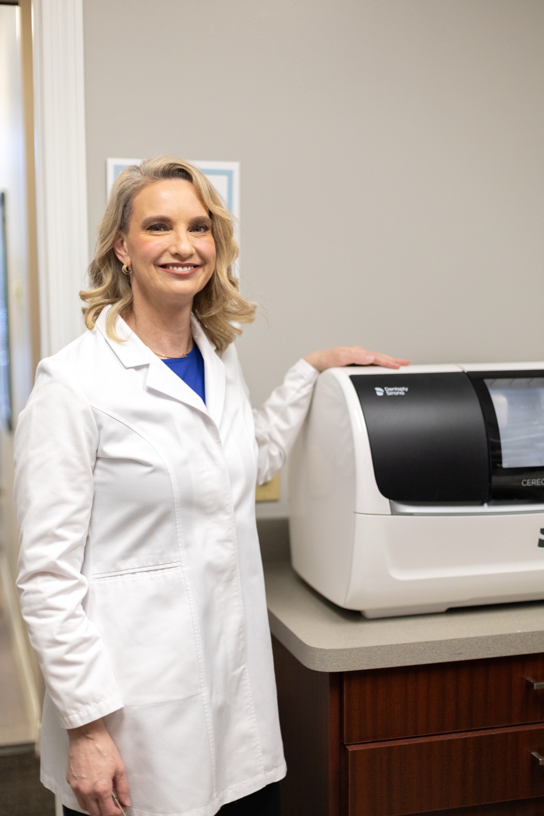 Dr. Allison House beside the in-office CEREC milling unit