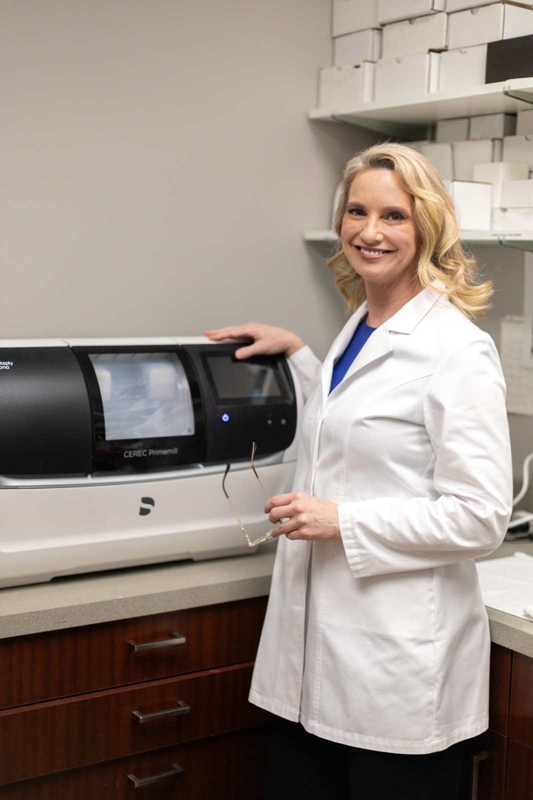 Dr. Allison House beside the in-office CEREC milling unit